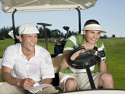 坐在球场高尔夫车的年轻男子高尔夫球手图片