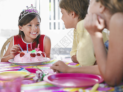 有生日蛋糕的年轻女孩 在户外生日派对上跟客人聊天图片
