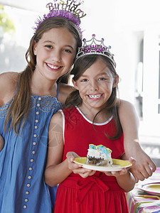 两个笑着的年轻女孩在头冠上的肖像闲暇朋友们女孩们友谊生日裙子享受幸福快乐食物图片