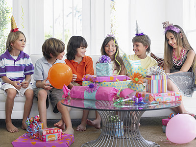 聚沙在生日派对上坐在沙发上的儿童群体(7-12)背景