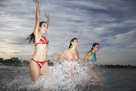 3名少女在海滩度假期间在海上泼水图片