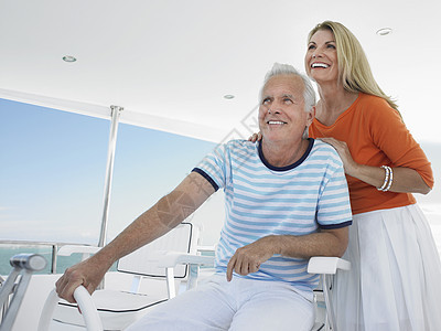 中年微笑的中年夫妇驾驶游艇图片