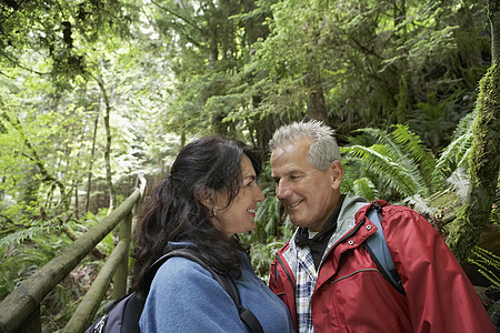 森林中的老年男子和中年妇女看着眼笑的目光图片