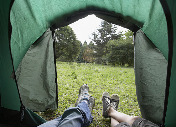 两名男孩躺在帐篷里看着脚享受兄弟活动乐趣草地假期场地农村兄弟姐妹团结图片