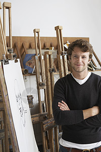 一个微笑的男性艺术家 站在木炭肖像摄影棚旁站着图片