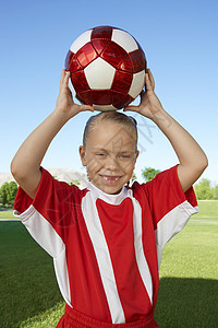 一名年轻女孩的肖像 她高头在田地上举着足球球满意高清图片素材