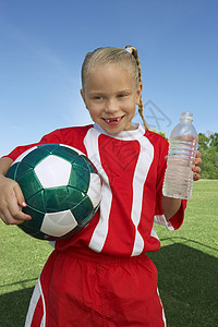 持有球和水瓶的年轻女子足球运动员的肖像天高清图片素材