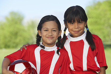 两名女性足球运动员的肖像 手围在田野上图片