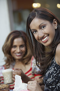 一个快乐的印度女人的肖像 朋友在咖啡桌边图片