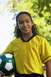 穿着黄色球衣 带着足球球的快乐少女肖像足球运动高清图片素材