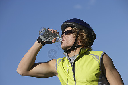 年轻男性骑自行车的男青年从瓶子到蓝天饮用水图片
