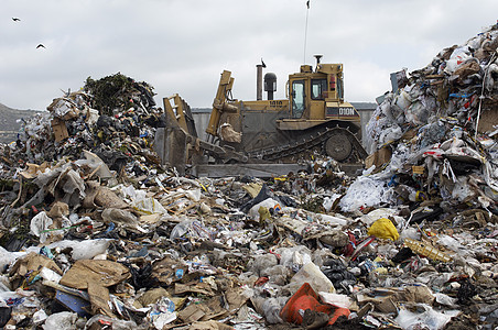 在垃圾倾倒场搬运垃圾的挖土车环境问题环境运输填埋场挖掘机倾倒图片