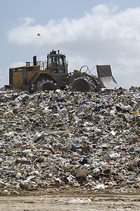在垃圾倾倒场搬运垃圾的挖土机运输倾销环境挖掘机环境问题填埋场背景图片