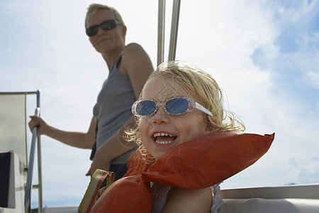 快乐的小女孩和妈妈 在游艇上与云天对抗图片