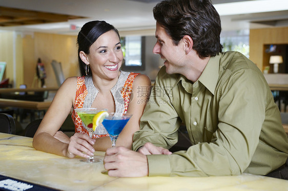 快乐的情侣在酒吧柜台享受马提尼图片