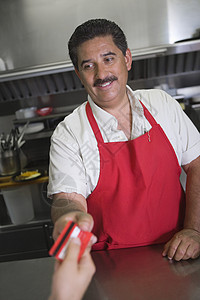 西班牙裔拉丁男老板在餐厅收到顾客付款图片
