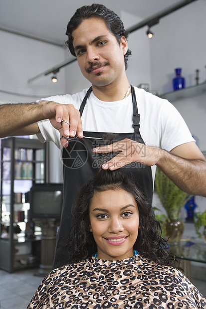理发师切割年轻女性头发的肖像图片