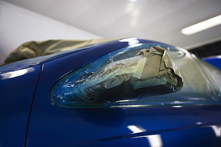 特写一辆蓝色汽车被损坏的车头灯图片