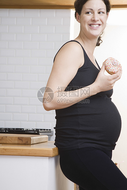 孕妇在厨房吃甜甜圈图片