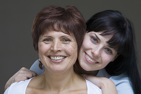 年轻女性拥抱母亲的片场肖像头肩个人中年成年友谊影棚家长妇女棕色微笑图片