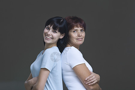 年轻女性和母亲背背背对背的演播室肖像图片