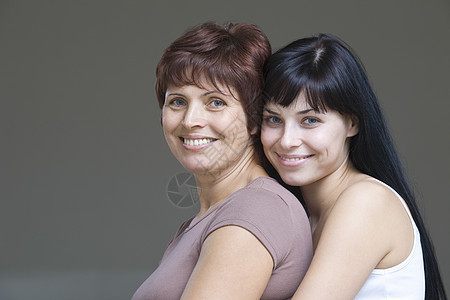 年轻女性拥抱母亲的片场肖像头发中年幸福女儿头肩个人家长棕色微笑友谊图片