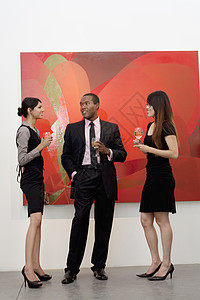 年轻高管在美术馆的绘画前聊天时图片