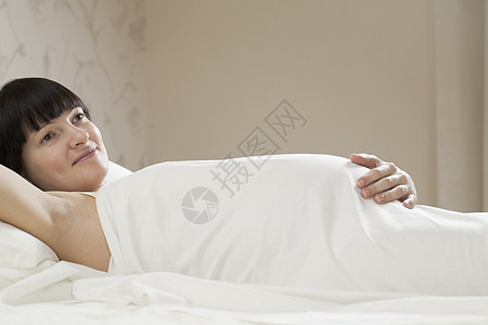 躺在床上的微笑的孕妇图片