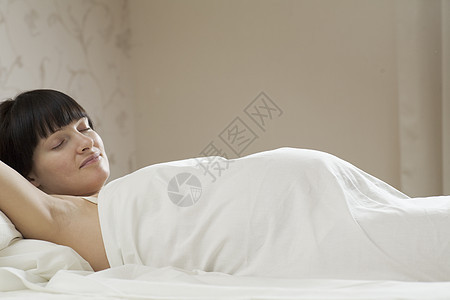 睡在床上的孕妇成年人女性孕产生育力年轻人幸福成年卧室成人开端图片