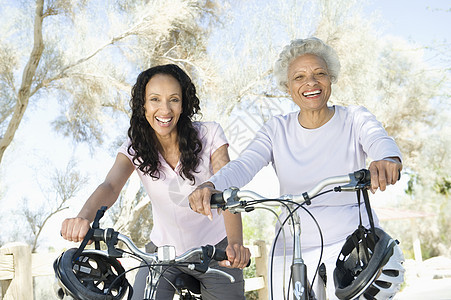 骑着山地自行车的母亲和女儿长发车把活动棕色两个人服装年龄女性女士孩子图片