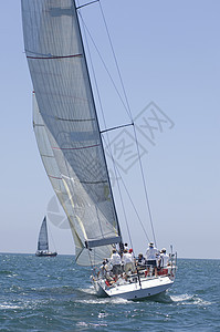 参加加利福尼亚州比赛队帆船赛的游艇船员运动划船日光竞技天空全体海洋地平线成人人员图片