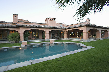 游泳池和草坪在宽敞的房屋前 对著清天而行图片