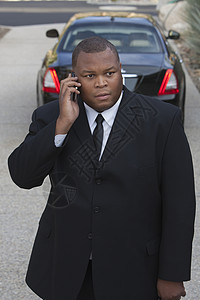 司机用豪华车在移动电话上站立西装一人外套听力服务套装手机职员黑色奢华图片