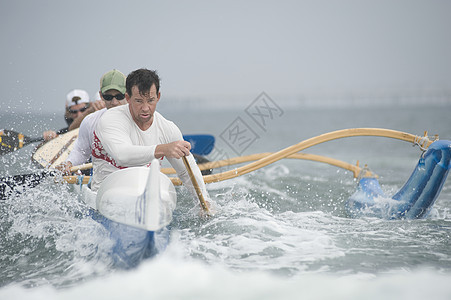 水上越野独木舟小组四个人外表运动员海女男士喷雾领导运动海洋平衡图片