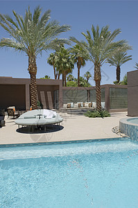 加利福尼亚家庭游泳池边有棕榈树的座位房子财产奢华水池天空建筑学晴天泳池游泳图片