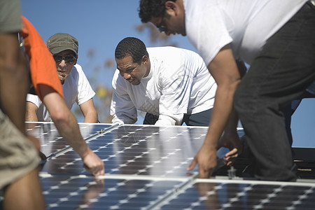 一群人埋下一个巨大的太阳能电池板男人团体光伏男子团结团队环境太阳能男士环境问题图片