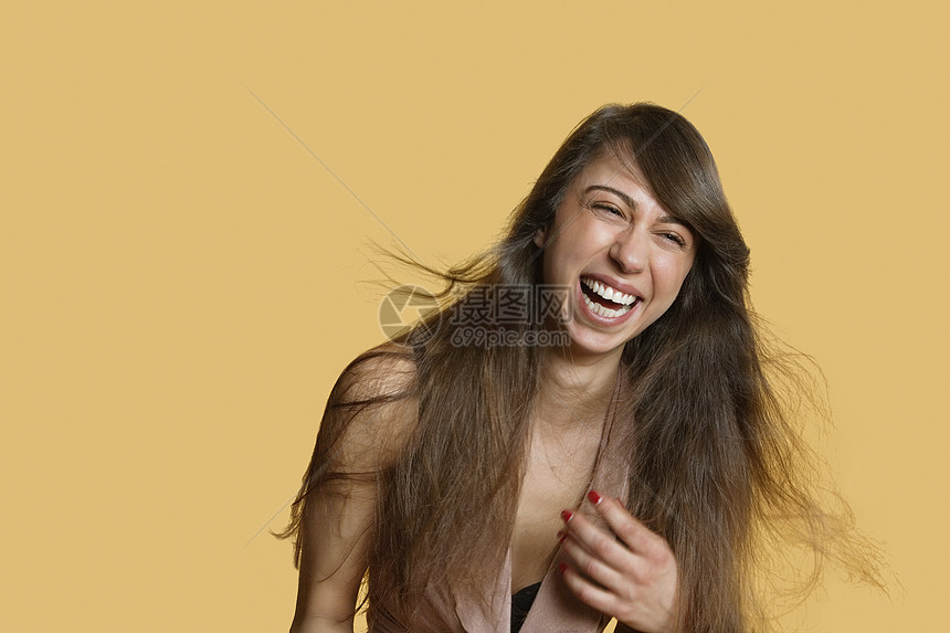 一位年轻女性为肤色背景而笑的肖像图片