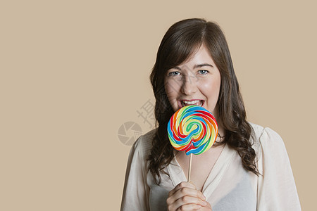 一位美丽的年轻美女的肖像 彩色背景上涂着棒棒棒棒糖图片