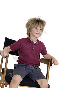 学校男孩坐在校长的椅子上 白种背景图片