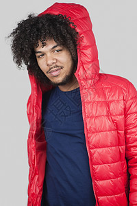 青年男子穿着红色夹克背心的肖像 头罩着彩色背景图片