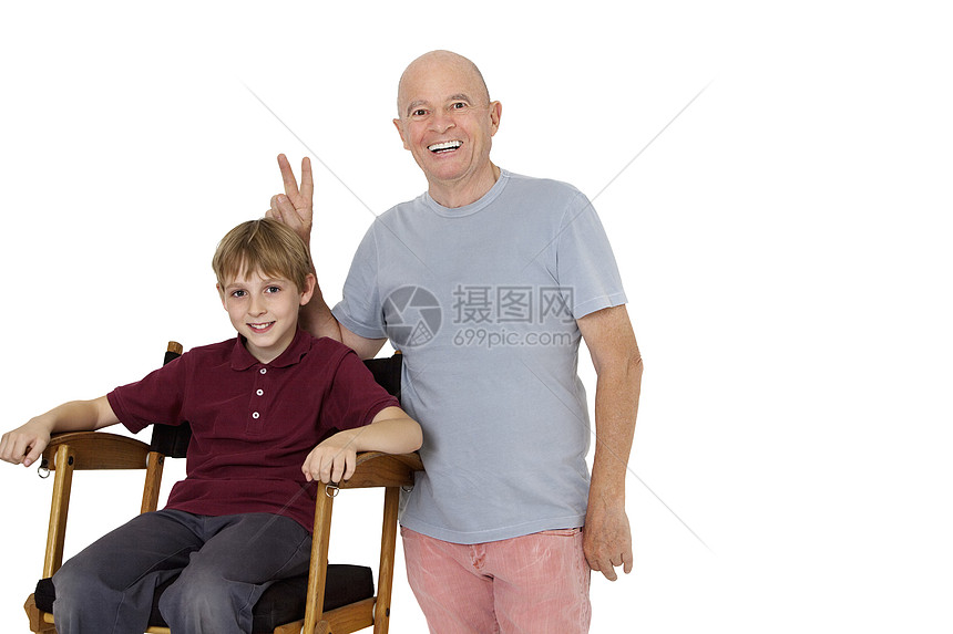 白色背景下坐在导演椅上的老人打着和平手势的画像图片