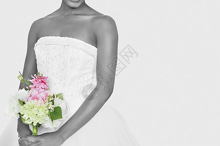 在灰色背景上拿着花束的新娘的中产体仪式成人裙子双手白色衣服庆典传统影棚开端图片