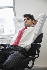 年轻的印度青年商务人士在坐在办公椅子上思考时考虑问题图片