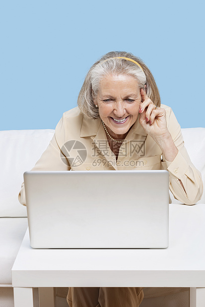 使用笔记本电脑进行视频通话的年长妇女服装白发退休短发桌子喜悦闲暇房子用户计算机图片