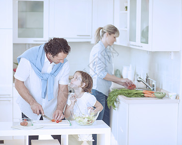 父亲和女儿在厨房准备健康餐时互相看着对方 同时在厨房做健康饭图片