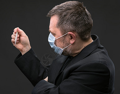 戴带温度计的医务面罩的人感染情绪防御面具程序治疗温度男人悲伤外科图片