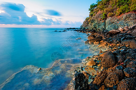 清凉海边冰冻的水面表面和岩石海岸背景