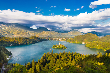 高山湖在斯洛文尼亚Julian Alps的湖中流血蓝色山脉反射假期风光旅游树木地标游客爬坡背景