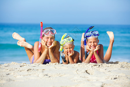 海滩上三个快乐的孩子呼吸管海洋面具海滨假期太阳女性兄弟潜水蓝色图片