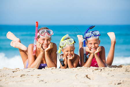 海滩上三个快乐的孩子天空享受乐趣太阳说谎浮潜面具男生潜水兄弟图片